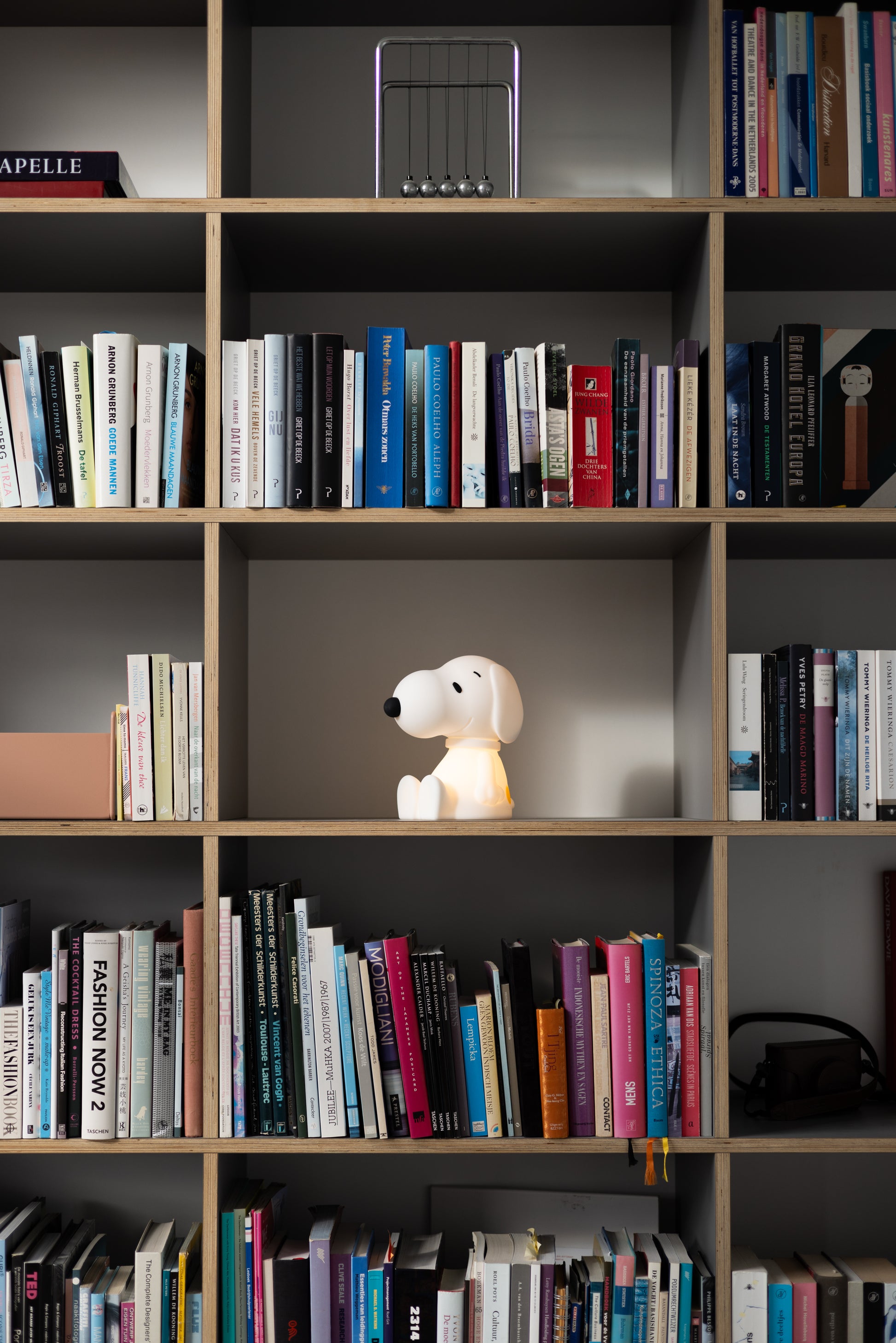 Snoopy First Light lamp placed beside a Peanuts comic book collection