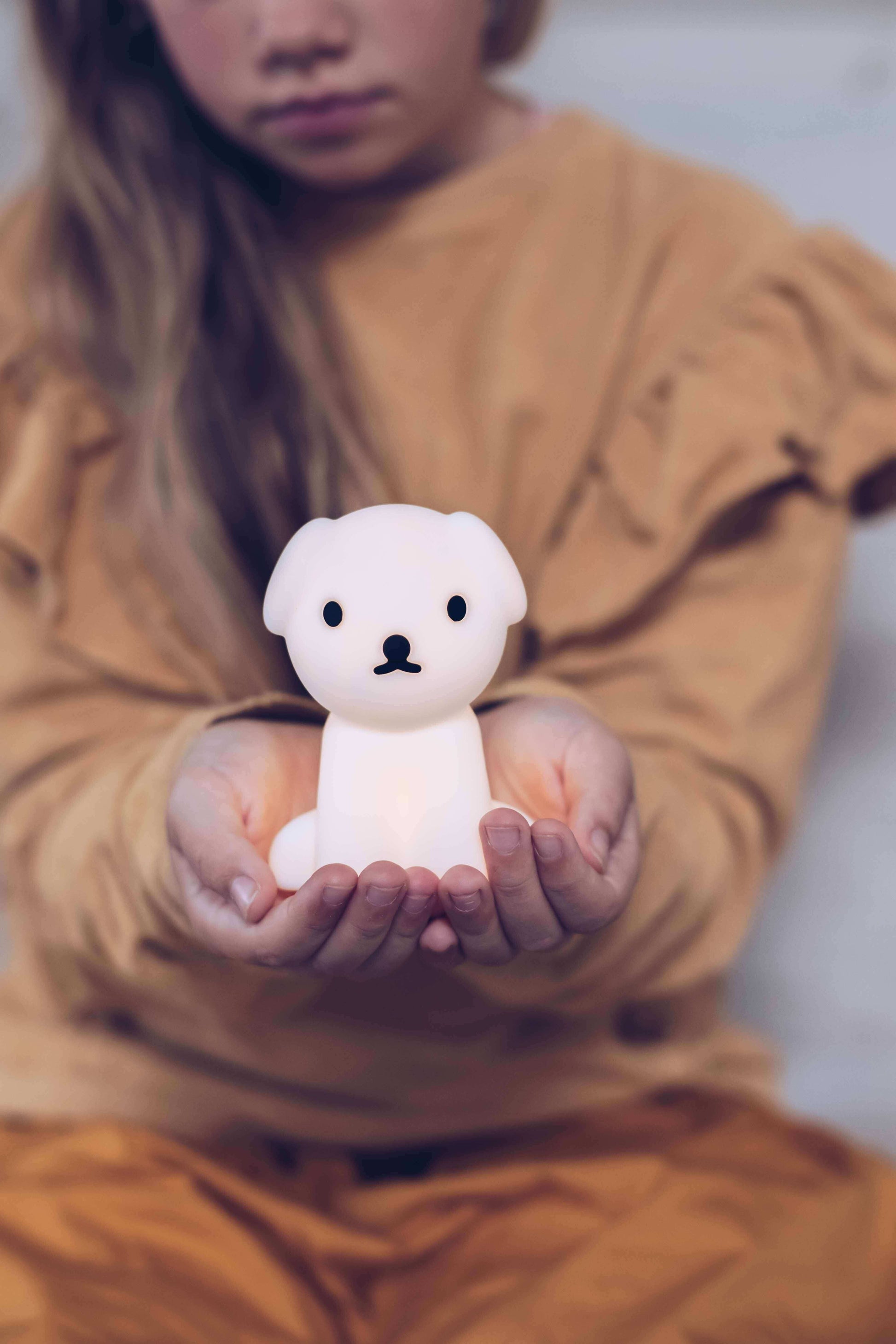 Child holding the portable Snuffy Bundle of Light lamp
