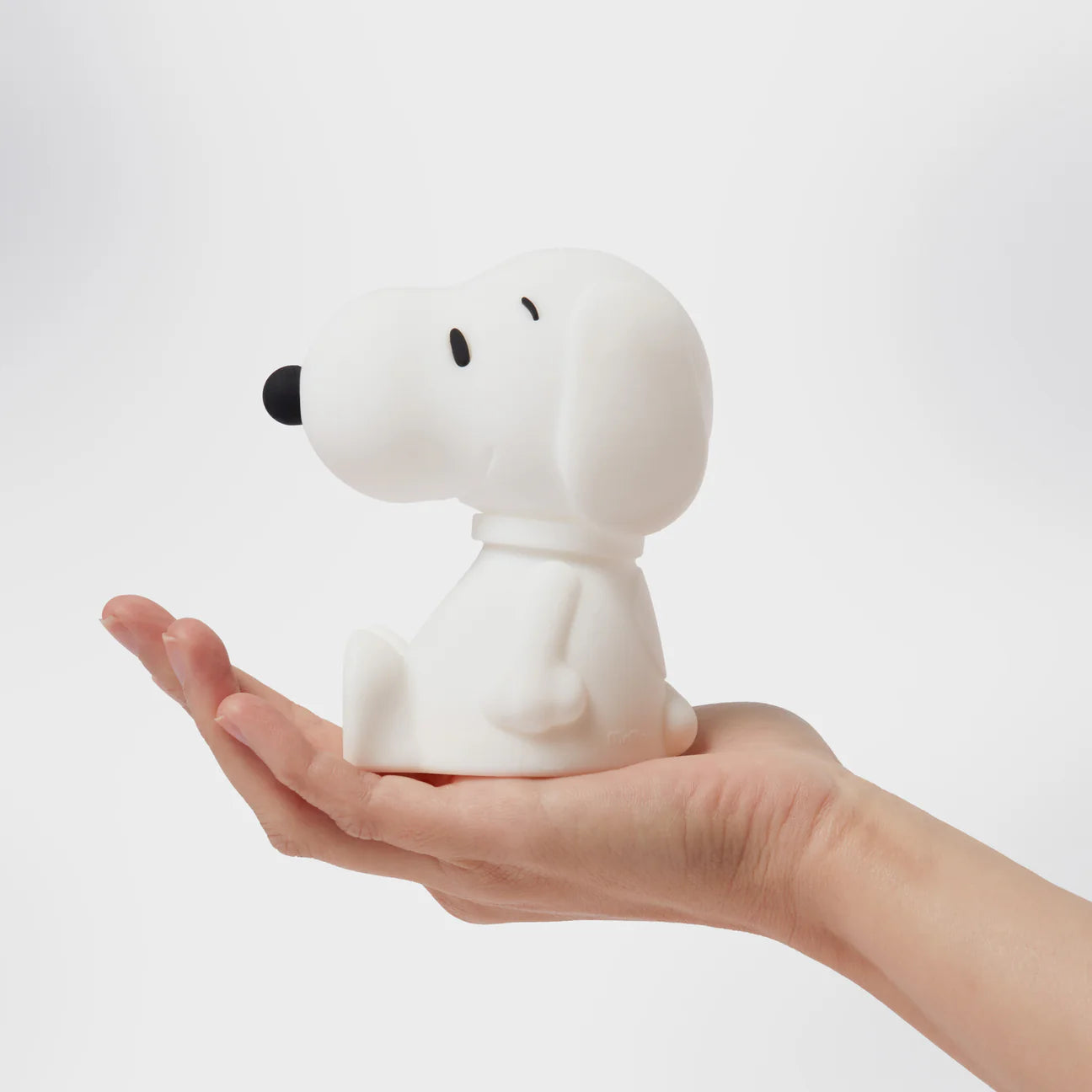 Child holding Snoopy First Light portable night lamp